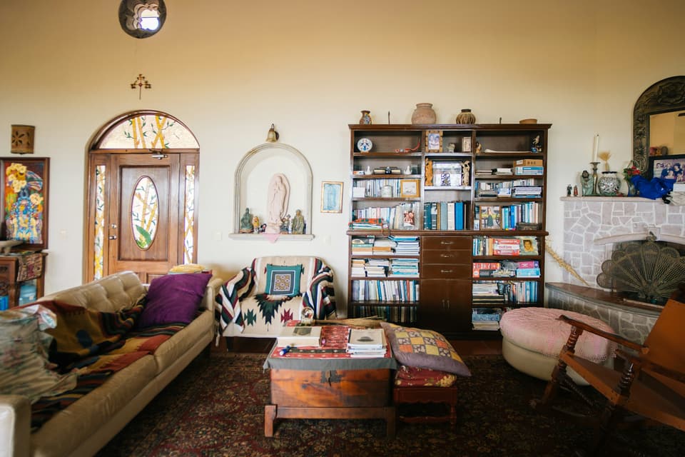 A lived-in living room with bookshelves, rugs and a sofa